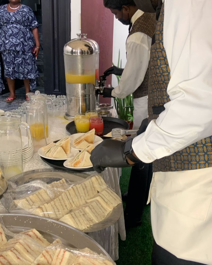 Festive Occassions staff in uniform serving drinks and sandwiches at an event